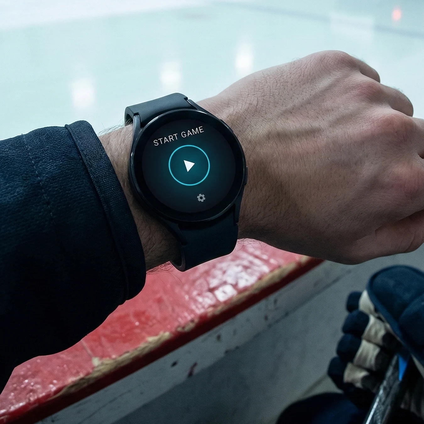 Hockey player starting a game on their Wear OS watch at the rink boards